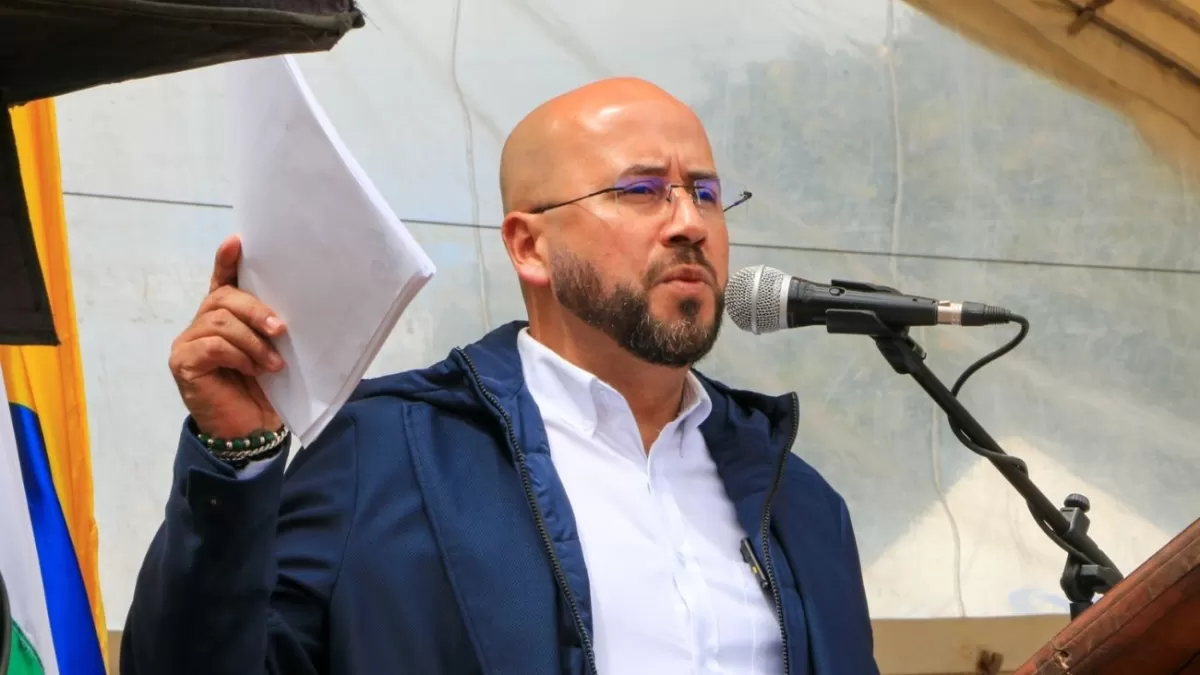 Persona hablando en un micrófono con unos papeles